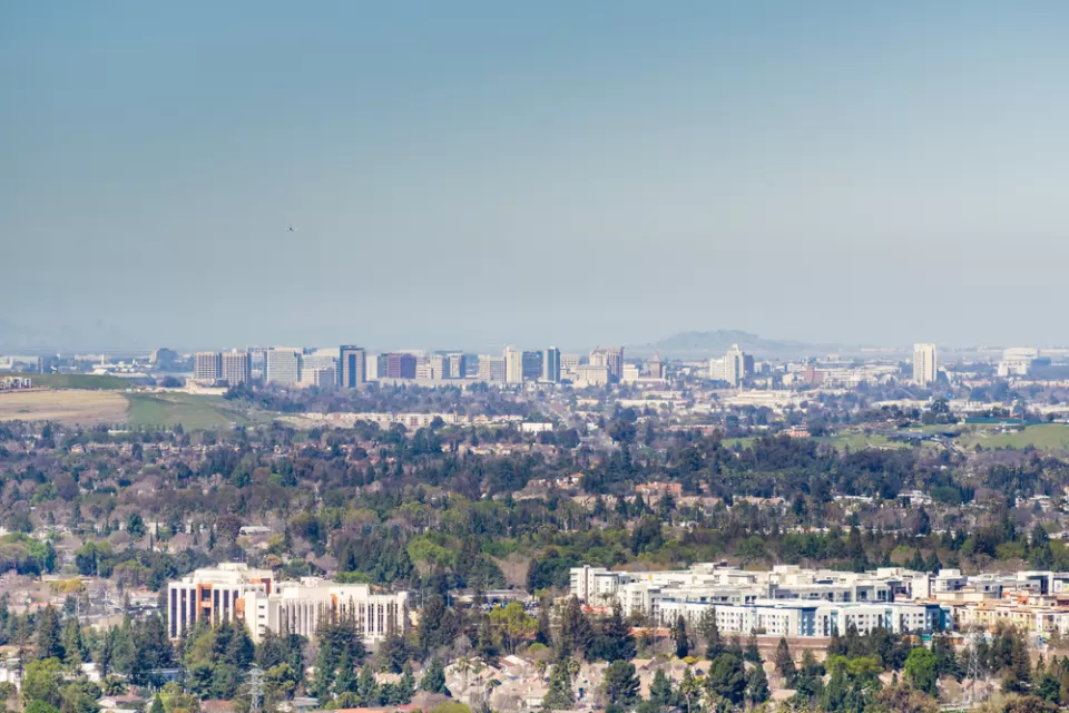 A view out over the city of San Jose, with downtown highrises in the background distance and smoggy air hanging overhead.